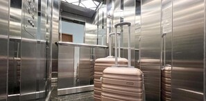 An elevator with a capacity of 8 people, featuring stainless steel walls and a handrail.