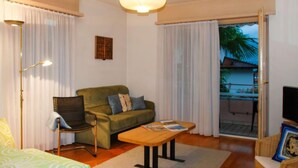 Una sala de estar acogedora con un sofá, una mesa de centro, una silla y un televisor.