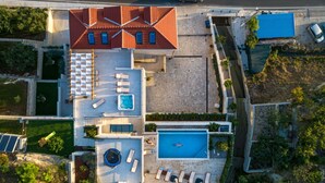An aerial view of a modern building with a rooftop pool, multiple lounge areas, and a large swimming pool. - Beautiful private villa for 12 people with A/C, private pool, WIFI, hot tub, TV and terrace (Solin)