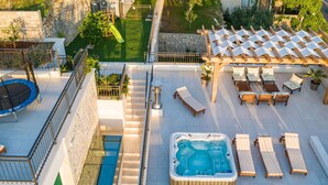 A rooftop with a hot tub, lounge chairs, and a trampoline. - Beautiful private villa for 12 people with A/C, private pool, WIFI, hot tub, TV and terrace (Solin)