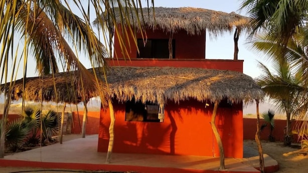 A red building with a thatched roof, surrounded by palm trees. - Las Palmas (Ejido Plutarco Elias Calles)