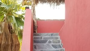 A staircase with stone steps and a red wall. - Las Palmas (Ejido Plutarco Elias Calles)