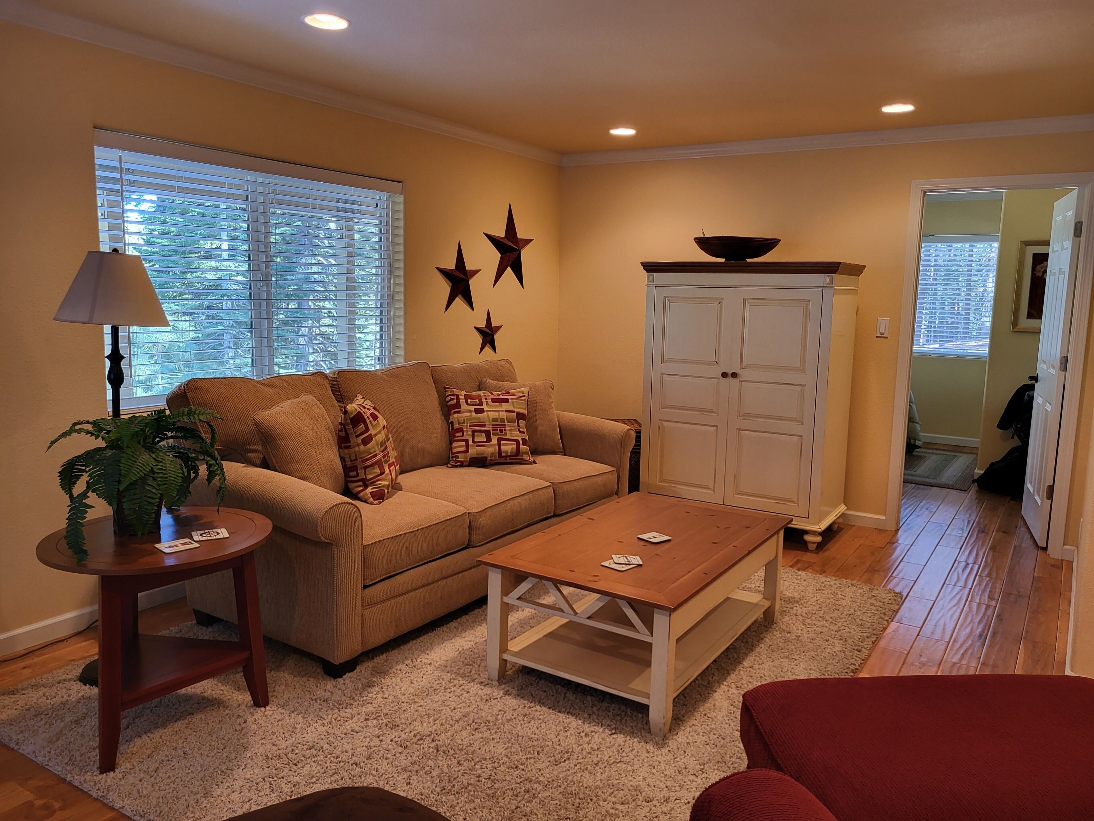 A living room with a sofa, coffee table, lamp, and decorative stars on the wall.
