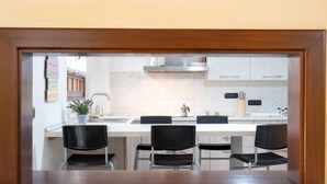 Een moderne keuken met witte kasten, een roestvrijstalen spoelbak en een zwart aanrecht.