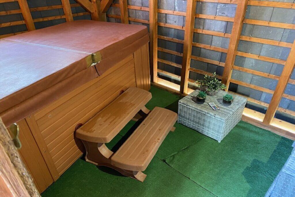 Een houten bank en tafel in een kamer met groene vloer en houten wand.