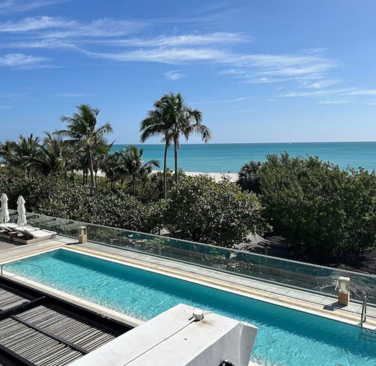 Una piscina con vista despejada a la playa y al océano.