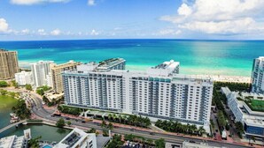 Ein Hochhotel mit mehreren Stockwerken, Blick auf den Strand und einem Yachthafen im Vordergrund.