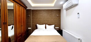 Ein Hotelzimmer mit einem großen Bett, einem Holzschrank und einer Deckenleuchte.