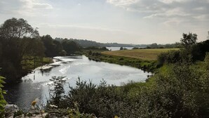 A river flowing through a rural landscape with fields and trees.