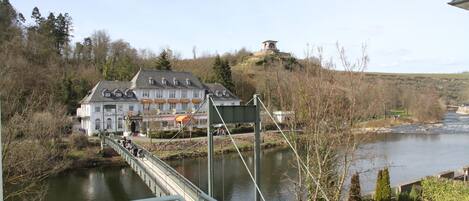 Eine Brücke über einen Fluss, im Hintergrund ein großes Gebäude.