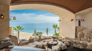 An indoor pool area with a view of the beach and ocean.