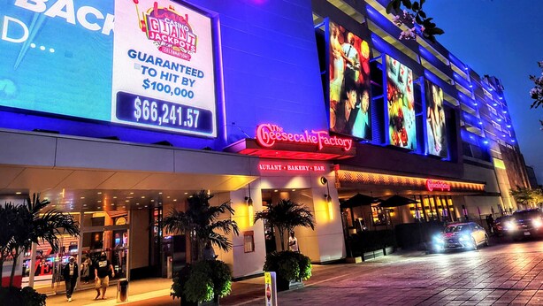 Un bâtiment de casino avec une enseigne lumineuse, comprenant un grand écran numérique affichant une publicité pour un jackpot de 66 241,57 $.