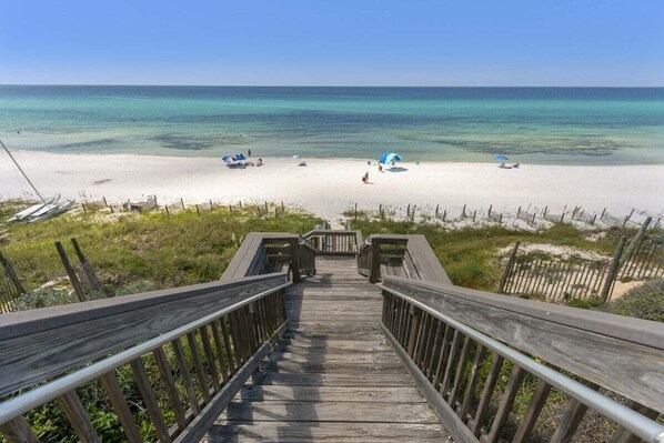 A wooden boardwalk leading to a beach with clear turquoise water and white sand. - Tranquillity on the Beach, 2025 Renovation, On the Beach, Heated Community Pool (Seacrest)