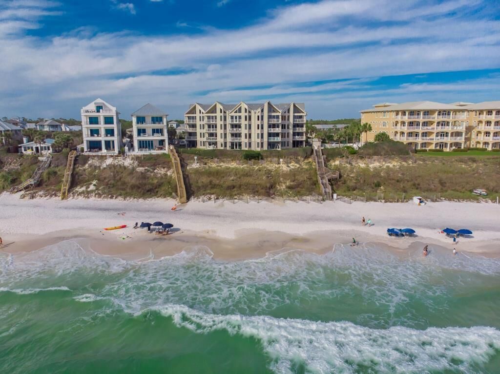 A beachfront hotel with multiple buildings, a sandy beach, and ocean waves.