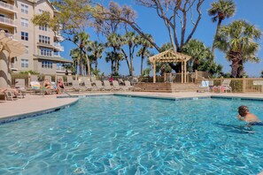 Uma área de piscina com espreguiçadeiras e um gazebo.