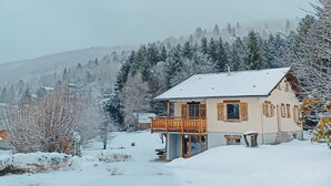 A snow-covered house with a balcony, surrounded by trees and a snowy landscape. - Well-being of the old do **** (Ventron)