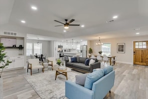 A modern living room with a sofa, coffee table, and dining area.