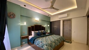 Una camera da letto moderna con un letto, una ventola a soffitto e un armadio.