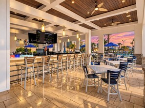 Resort poolside bar and dining patio at sunset