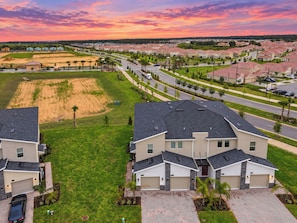 A residential area with modern houses, a well-maintained lawn, and a clear sky.