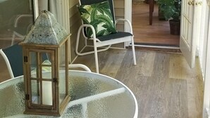 A covered patio with a glass table, chairs, a lantern, and a ceiling fan. - Beautiful, 3 br/2 bath condo in Pawleys Island, SC. Minutes from the beach. (Pawleys Island)