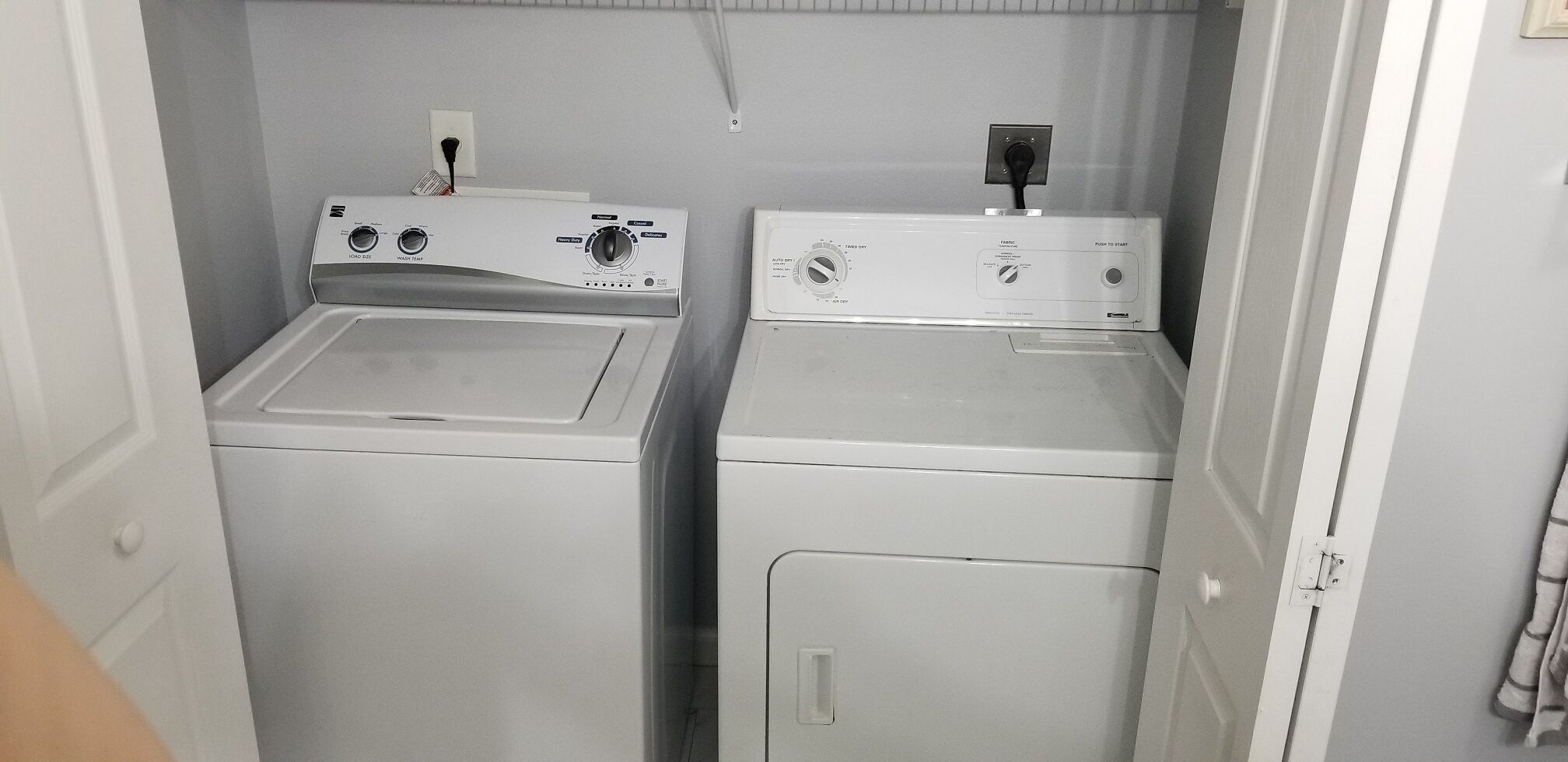A laundry room with two front-loading washing machines and a dryer.
