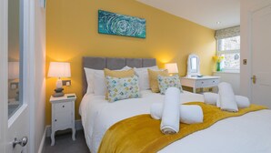 A hotel room with a bed, bedside tables, a desk, and a window with a view. - Summer Salt – St Ives – Sleeps 4 – Parking – Outside Space (St Ives)