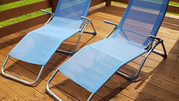 Two blue lounge chairs on a wooden deck with a wooden railing. - Gemütliches Ferienhaus am Twistesee im Ferienland Waldeck-frankenberg (Bad Arolsen-Wetterburg)