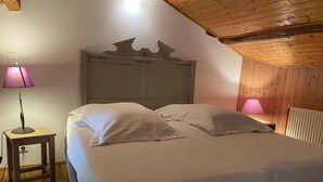 Une chambre à coucher avec un lit, deux lampes de chevet et un plafond en bois.