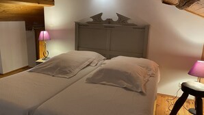 Une chambre à coucher avec un lit double, deux lampes de chevet et un plafond en bois.