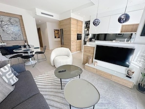 Un salon moderne comprenant un canapé, une table basse, un téléviseur et un coin repas.
