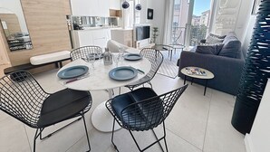 Un appartement moderne comprenant un coin repas, une cuisine et un espace de vie.