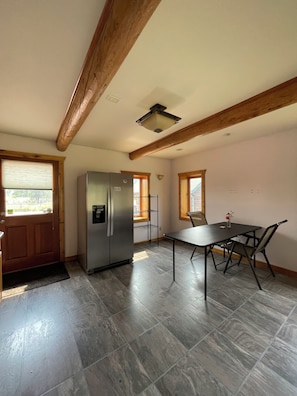 A kitchen with a built-in refrigerator, a dining table with chairs, and a window with blinds. - New Listing! Spacious Montana cabin near downtown Whitefish (Whitefish)