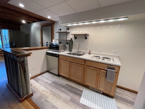 A modern kitchen with a dishwasher, microwave, sink, and stove. - New Listing! Spacious Montana cabin near downtown Whitefish (Whitefish)