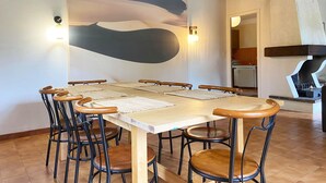 Ein Essbereich mit einem großen Tisch, sechs Stühlen und einem modernen, abstrakten Gemälde an der Wand.