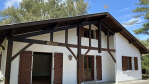 Ein Gebäude mit weißer Fassade, Holzbalken und braunen Fensterläden.