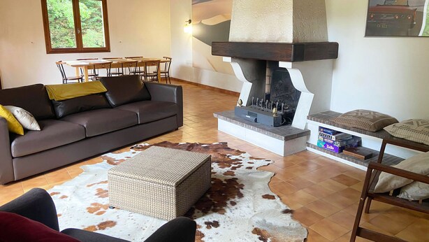 Ein gemütliches Wohnzimmer mit einer Couch, einem Couchtisch, einem Kamin und einem Essbereich mit Tisch und Stühlen.