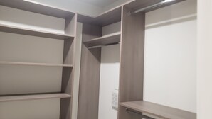 Un vestidor con múltiples estantes y una puerta.