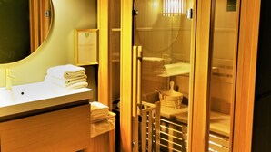 Un bagno moderno con un mobile bagno in legno, uno specchio e una cabina doccia in vetro.