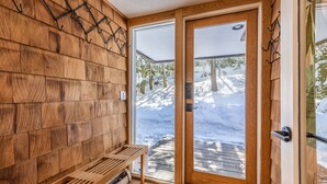 A wooden interior with a bench and a door leading outside. - 2026 Seasonal Summer Rental (Winhall)