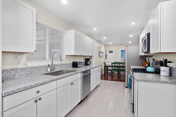 Enjoy cooking in this well-equipped kitchen with a dishwasher, coffee maker, and stove, and dine at the adjacent table.