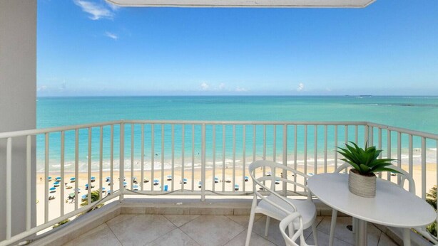Een balkon met uitzicht op een strand en zee.
