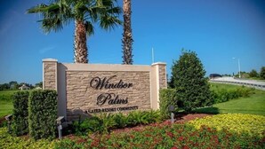 Segnaletica per Windsor Palms, parte della Green Resort Community, con un giardino curato e palme.