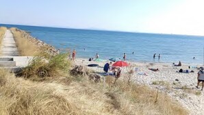 A beach with people swimming and sunbathing, a concrete path, and some greenery. - 1-bed Modern Sea View Apartment in Aparthotel (Pomorie)