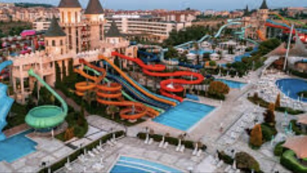A water park with multiple slides and pools, surrounded by buildings. - 1-bed Modern Sea View Apartment in Aparthotel (Pomorie)