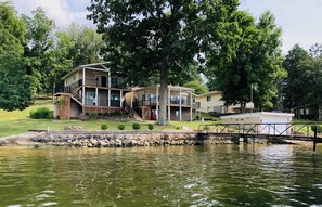 A lakeside property with a multi-story building, a dock, and a stone retaining wall. - JOMO TriTerrace Enjoy Family, Relax Lakefront, Lake View, Priv dock Boat Slip (Rocky Mount)