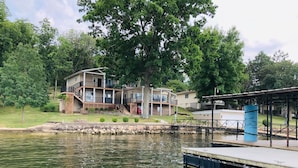 A waterfront property with a dock, a covered area, and a multi-story building with balconies. - JOMO TriTerrace Enjoy Family, Relax Lakefront, Lake View, Priv dock Boat Slip (Rocky Mount)