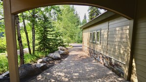 A paved pathway leading to a building with a stone wall and wooden siding. - Hart of McCall - Mountain retreat with hot tub and sauna near downtown and golf (McCall)