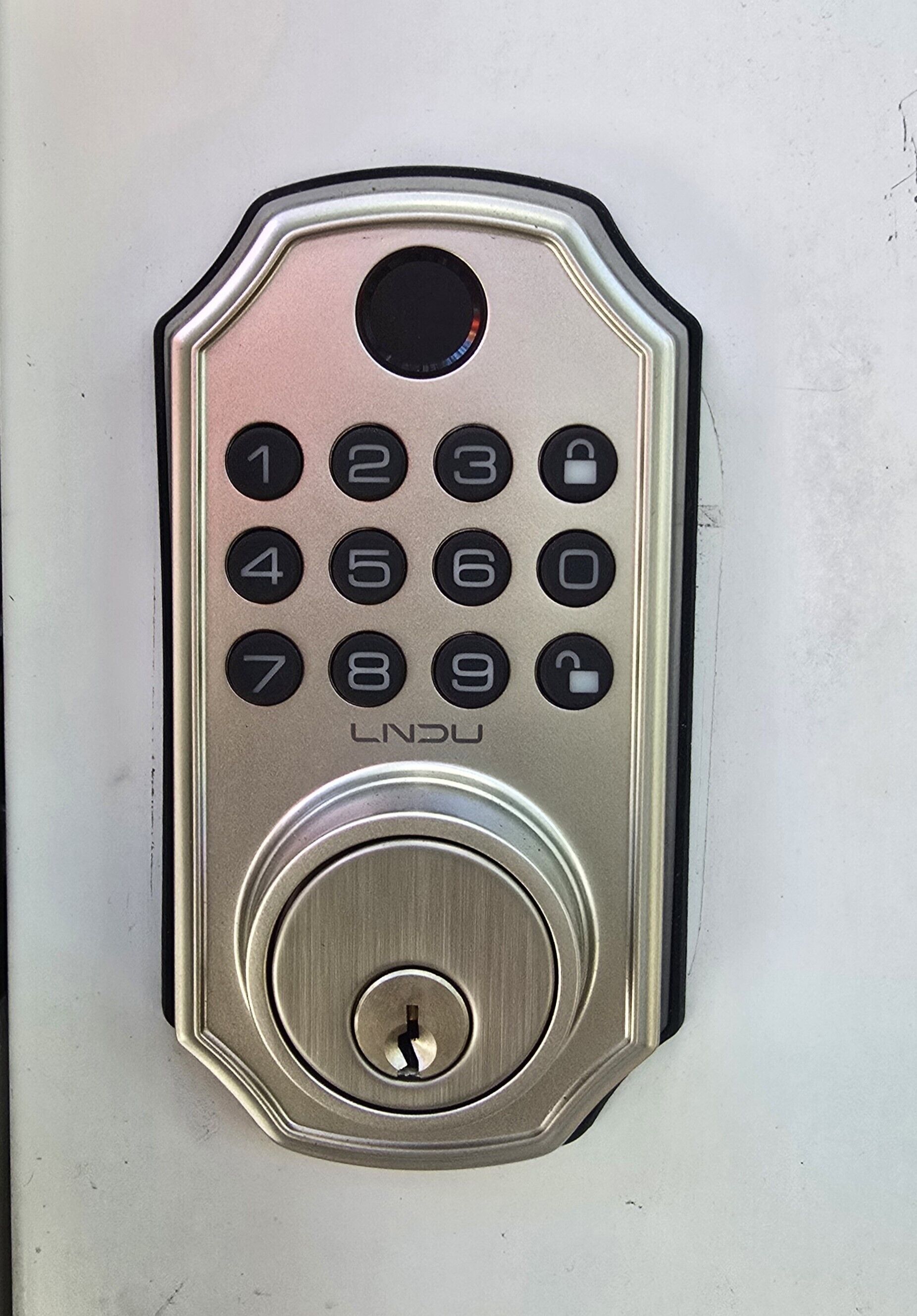 Een numeriek toetsenbord slot met een sleutelgat eronder.