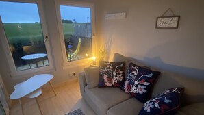 A cozy living room with a sofa, patterned rug, and a small table.